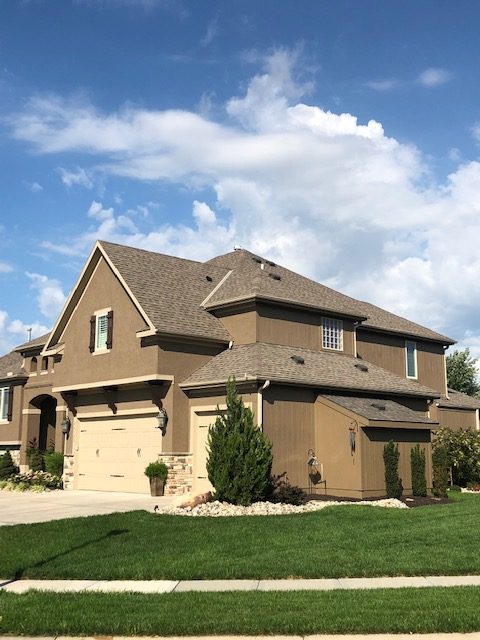 A large brown house with a quality roof by Kansas City residential roofing company Buck Roofing